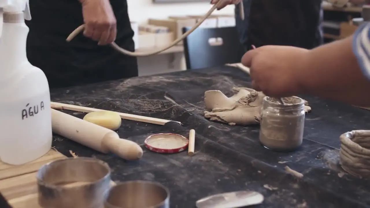 Beginners hand-building clay at a workshop table