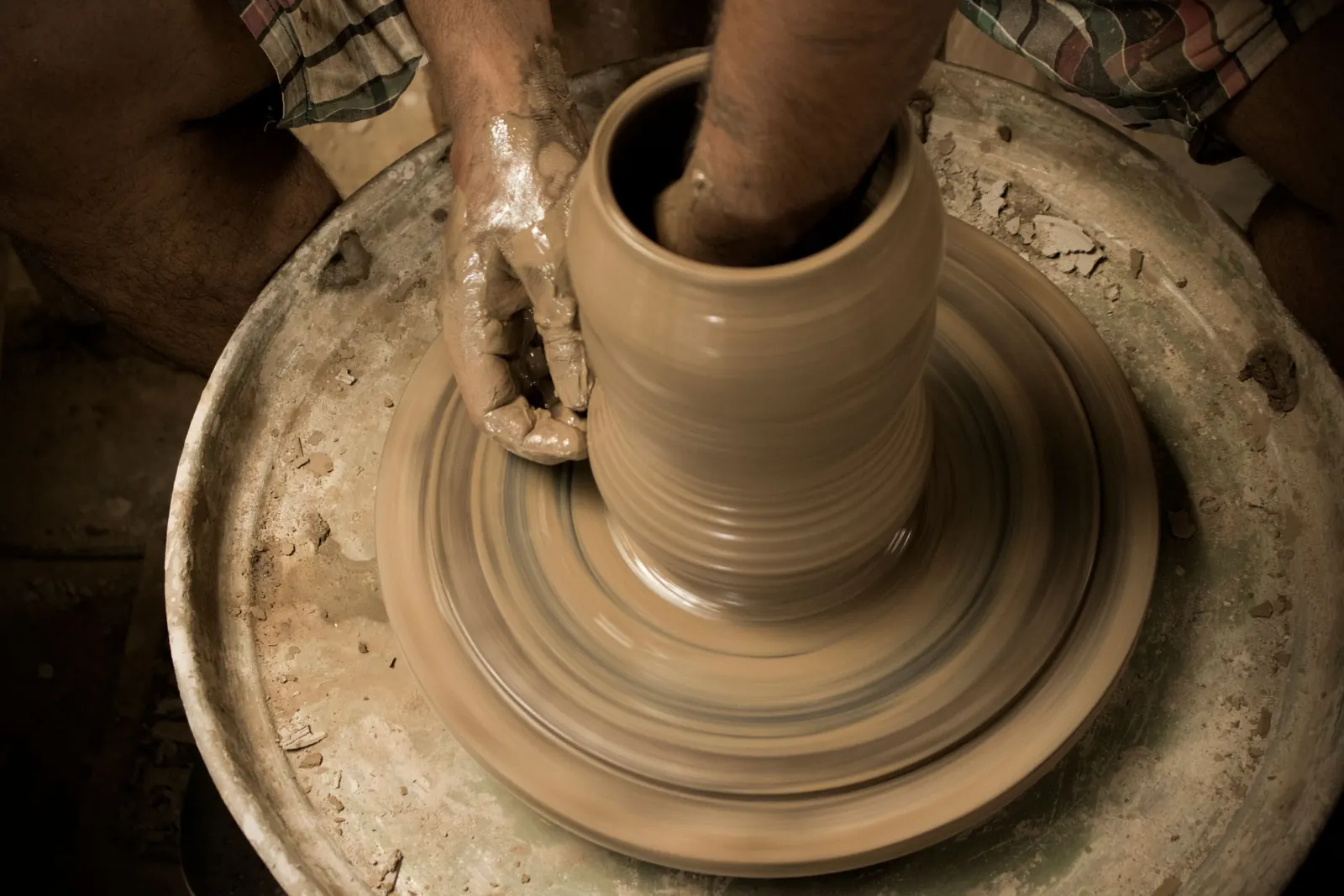 Hands shaping a pot