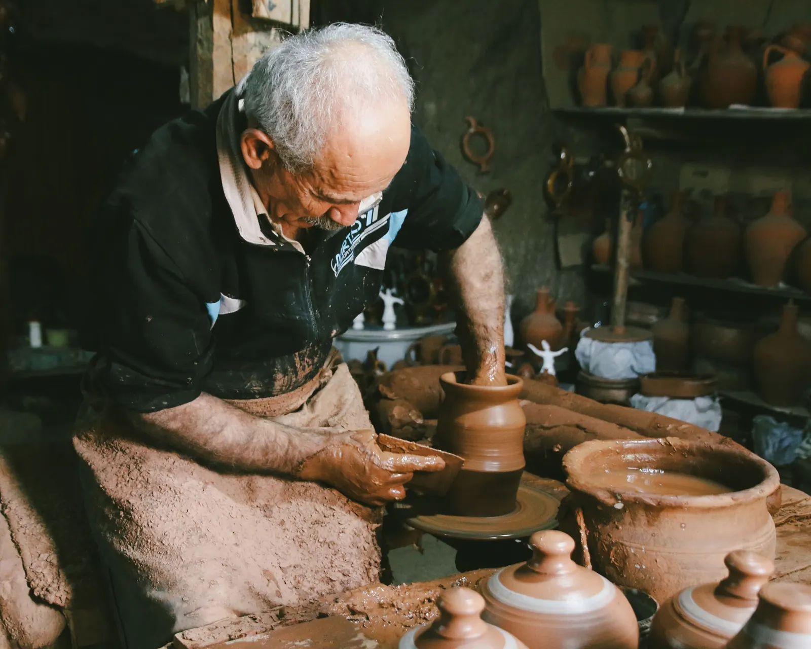 A potter at the wheel in a workshop